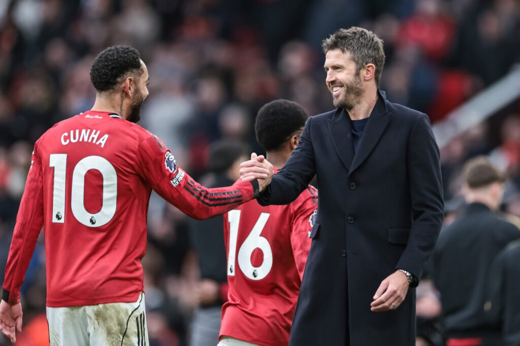 Michael Carrick félicite Matheus Cunha à la fin d'un match de Manchester United