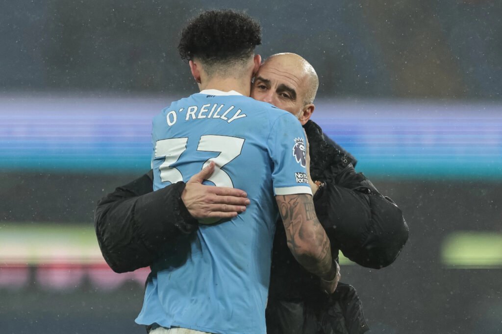 Pep Guardiola sert Nico O'Reilly dans ses bras lors d'un match de Manchester City